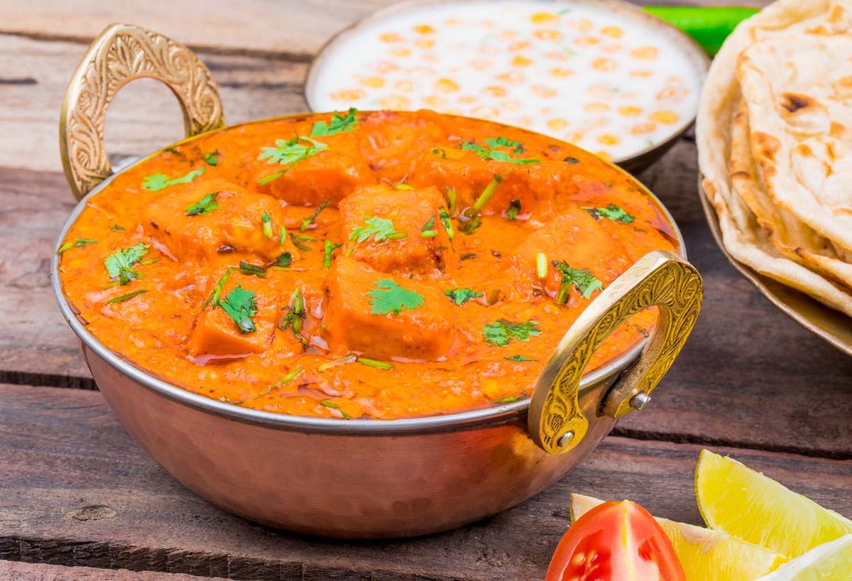 Delicious Indian paneer curry in creamy tomato sauce served with naan and rice.